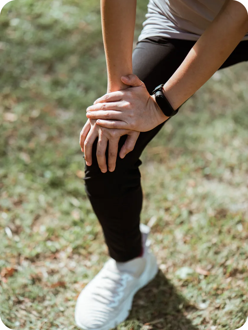 Person holding their knee in pain — genicular artery embolization for knee osteoarthritis in San Antonio